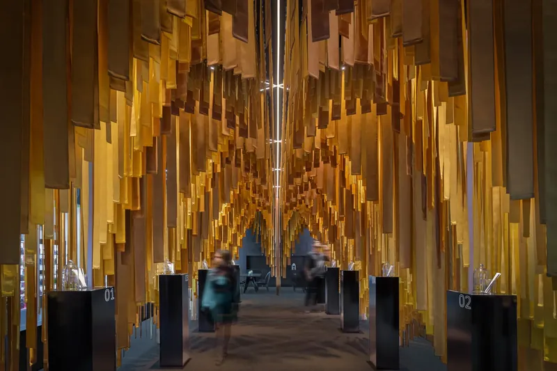 Luminescents, a pavilion for MANE in Dubai: a corridor of suspended fabric strips