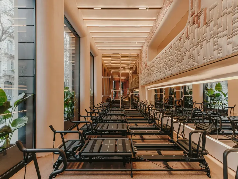 Repeat Wellness Club, Barcelona: rows of reformers beside tall windows under a sculpted wall